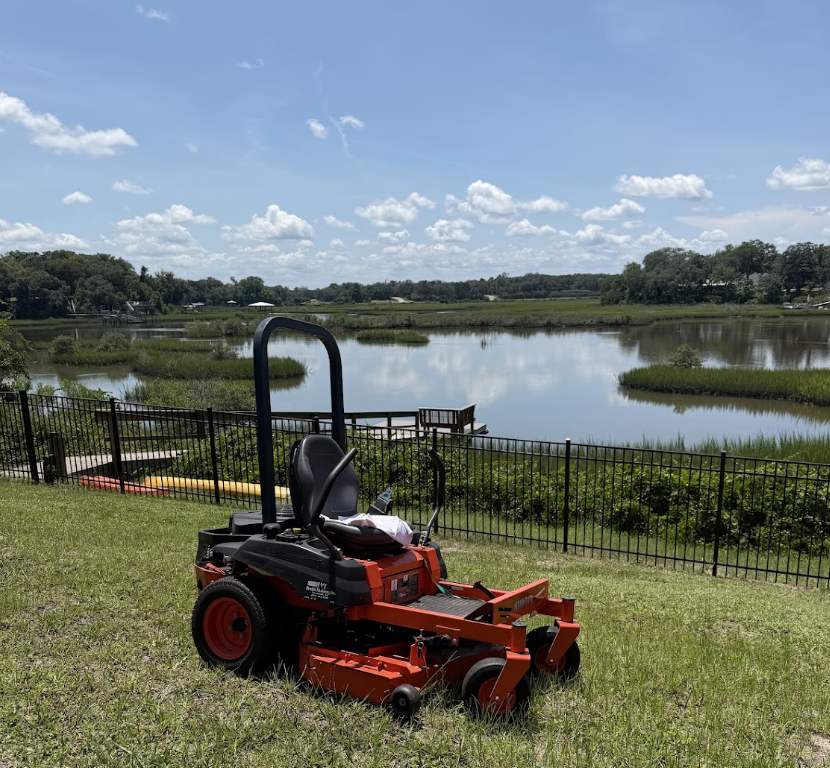 Commercial zero-turn mower on a St. Augustine lawn overlooking the water